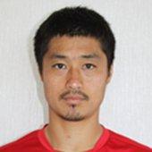 赤いシャツを着て真正面からカメラを見据える小笠原満男氏の写真