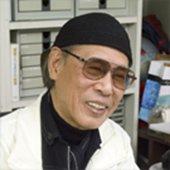 サングラスと帽子を着けてほほ笑むやなせたかし氏の写真