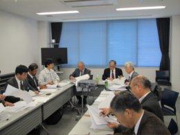 会議室内で資料に目を通しながら協議を行う専門家たちの写真