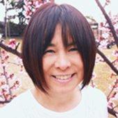 梅の花が咲いている屋外で撮影された白井貴子氏の写真