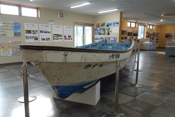 鉛色のポールで囲まれて展示されている実習船「かもめ」の写真