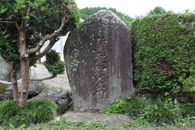 陸前高田市広田町にある一軒家の前に建立された上部に右読みでつなみと彫られその下に溺死記念碑と彫られた先端が三角形の石碑の写真