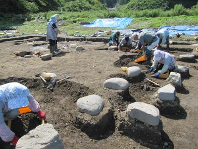 東北地方太平洋沖地震によって全壊した吉田家住宅の跡地で調査と実測をおこなう地域住民らの様子を撮影した写真