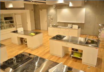 流し台のあるキッチンが複数置かれた明るい調理室の写真