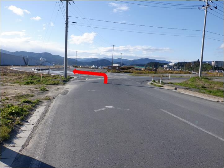 車道の写真に、T字路を左方向に曲がる赤い矢印が付いている写真