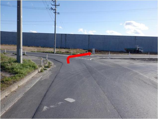 車道の写真に、T字路を右方向に曲がる赤い矢印が付いている写真