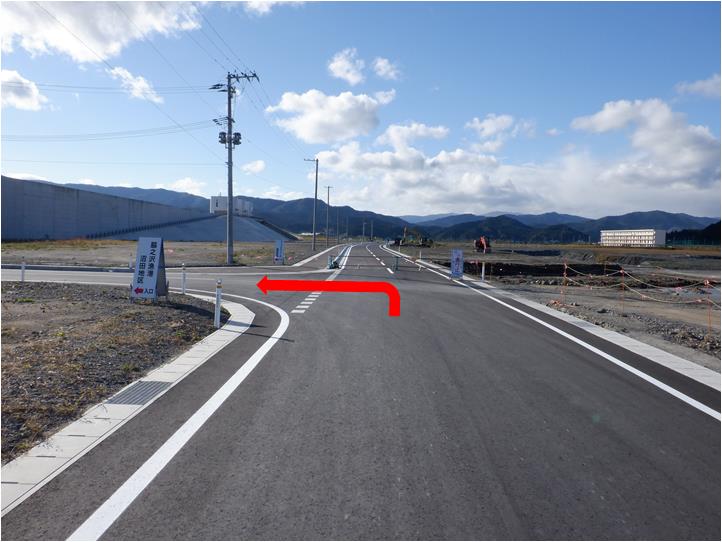 車道の写真に、T字路を左方向に曲がる赤い矢印が付いている写真