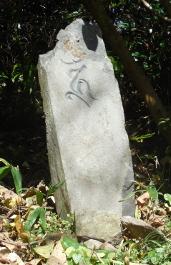 気仙町にある要谷館跡に建つ石の上側に梵字一文字が彫られ左側に傾いている阿閦如来種子板碑の写真