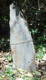 気仙町にある要谷館跡に建つ石の先端が尖った梵字一文字が彫られその下に縄が巻かれ左側に傾いている阿弥陀如来種子板碑の写真