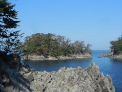 雲一つない青空の下陸前高田市広田町にある広田半島南端の岩礁群と青松島を撮影した写真
