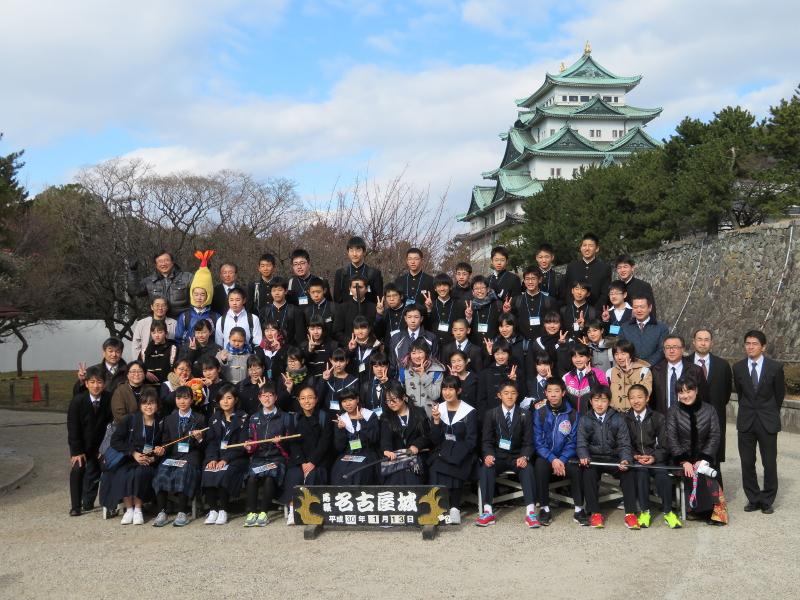 名古屋城をバックに縦5列で横に並ぶ陸前高田市と名古屋市の中学2年生の生徒らとその前にある名古屋城と書かれた置物の記念撮影での写真
